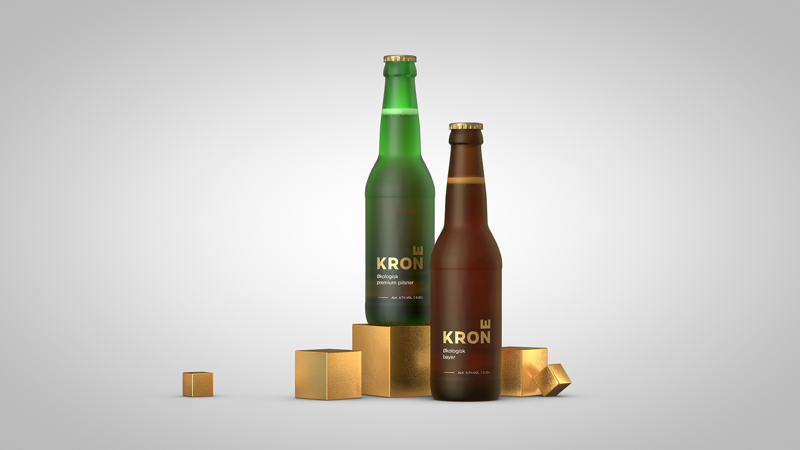 To Krone-flasker, grønn pilsner og brun bayer, på gullfargede terninger mot lys bakgrunn